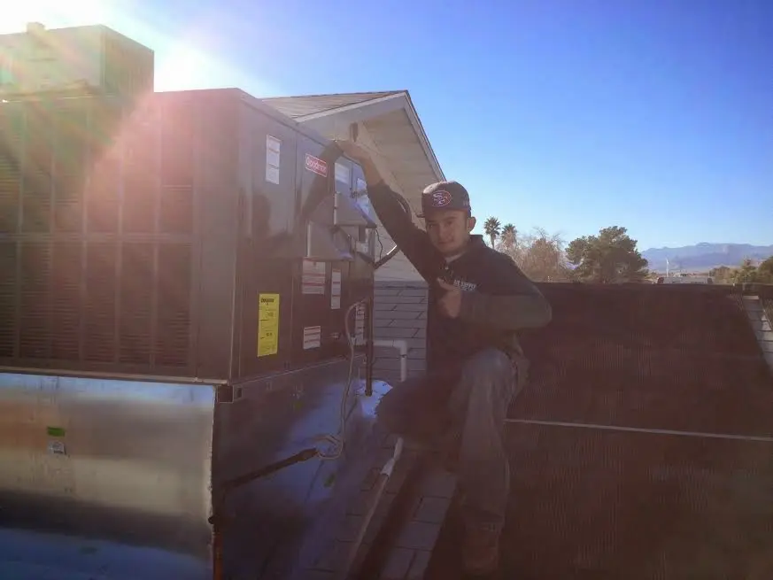 HVAC technician performing AC Tune-Up on a rooftop unit in Helena Valley West Central